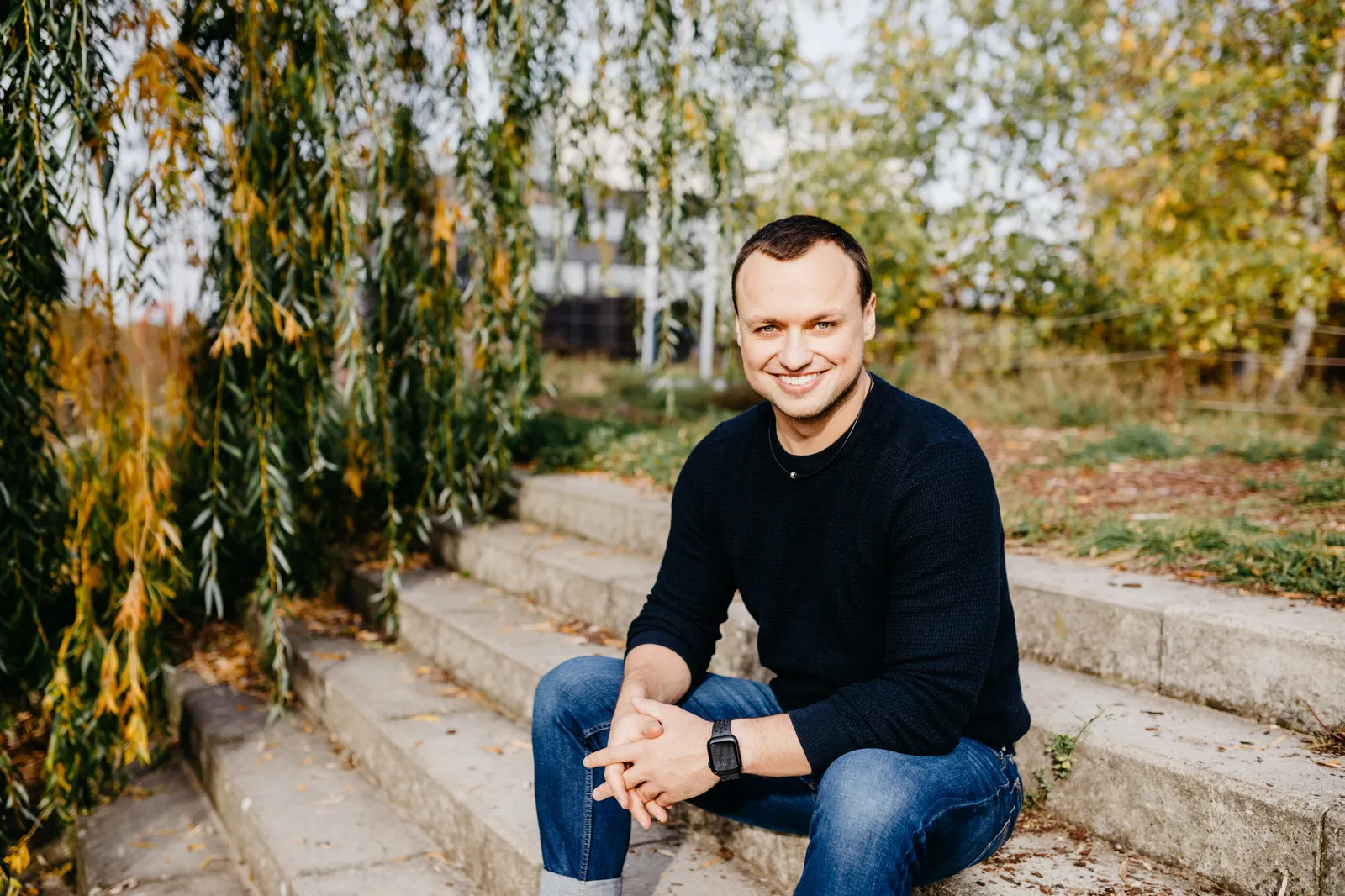 Timo Maletschek sitzt entspannt auf einer Treppe im Herbst